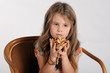 Little girl with the flower sitting on the chair