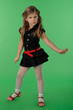 Little cute girl in black dress and red shoes