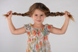 Little cute girl holding her long curly hair