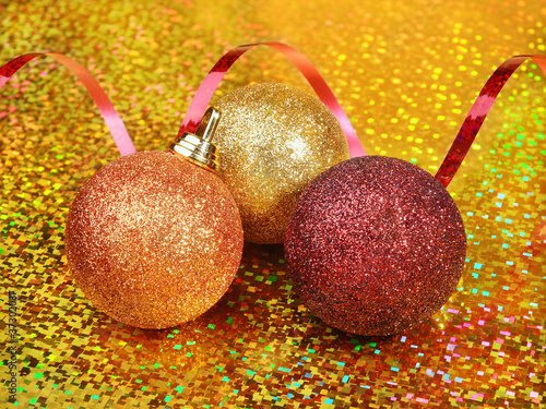 Photo: Sparkling Christmas balls on golden background Sparkling Christmas balls on golden background