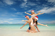Photo: Happy friends in santa hats on the beach. Christmas vacation Happy friends in santa hats on the beach. Christmas vacation