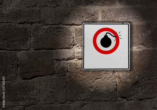 Foto: Schild an der Mauer Risiko explosiv Schild an der Mauer Risiko explosiv