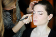 Young beautiful woman applying wedding make-up by make-up artist