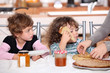 Two children at kitchen table having breakfast