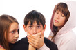 Two girls harrasing frightened boy