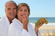 Couple eating grapes for breakfast on the  beach