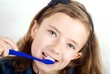 Foto: Girl brushing teeth on white background Girl brushing teeth on white background