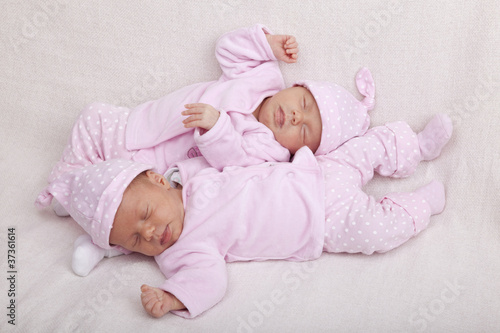 Foto: identical twin girls sleeping on a sofa identical twin girls sleeping on a sofa
