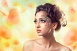 Photo: Young beautiful woman over spring/summer flowers background Young beautiful woman over spring/summer flowers background