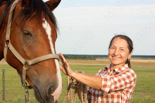 Foto: woman walking with her horse woman walking with her horse