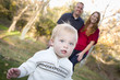 Cute Young Boy Walking as Parents Look On From Behind