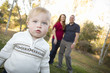 Cute Young Boy Walking as Parents Look On From Behind