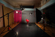 Empty dark photo studio with many modern lighting equipment