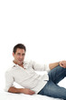Homme en chemise blanche allongé sur le sol