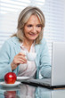 Woman Working on Laptop While Having Cup of Tea