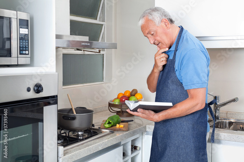 Photo: Senior Man Holding Recipe Book Senior Man Holding Recipe Book