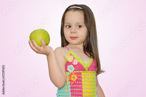 Foto: Portrait of a beautiful girl with green apple in hand Portrait of a beautiful girl with green apple in hand