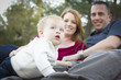 Photo: Cute Child Looks Up to Sky as Young Parents Smile Cute Child Looks Up to Sky as Young Parents Smile