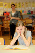 Gestresste Schülerin in der Schule mit einem Buch vor sich