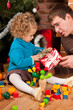 Little girl with gift box near  near Christmas tree
