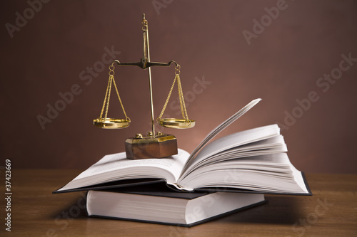 Photo: Scales of justice and gavel on desk with dark background Scales of justice and gavel on desk with dark background