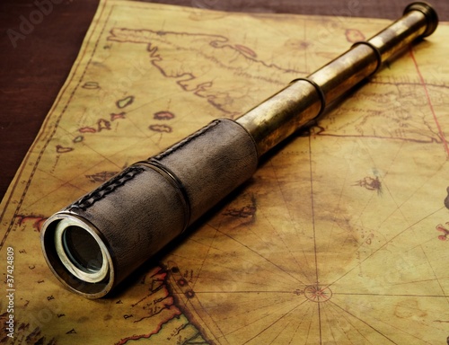 Photo: Close-up of a spyglass on the old map Close-up of a spyglass on the old map
