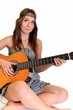 Une belle jeune femme adolescente avec une guitare acoustique Une belle jeune femme adolescente avec une guitare acoustique