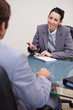 Smiling businesswoman with notepad in negotiation