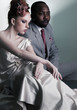 Two fashion models sitting - black man and red head woman