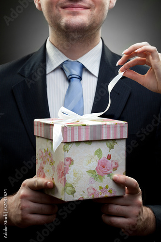 Photo: closeup portrait of businessman holding gift with womans hand closeup portrait of businessman holding gift with womans hand
