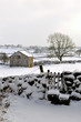 Winter snow scene with barn and stile