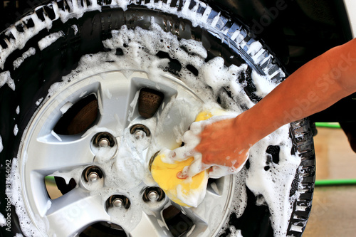 Photo: Washing a car tire. With a sponge and shampoo Washing a car tire. With a sponge and shampoo
