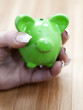 main préservant un cochon tirelire vert
