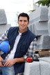 Construction worker stood holding hard hat