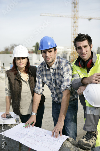 Photo: A team of tradespeople discussing a blueprint A team of tradespeople discussing a blueprint