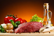 Raw beef on cutting board and vegetables