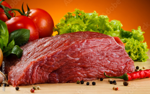 Photo: Raw beef on cutting board and vegetables Raw beef on cutting board and vegetables