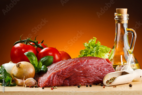 Foto: Raw beef on cutting board and vegetables Raw beef on cutting board and vegetables