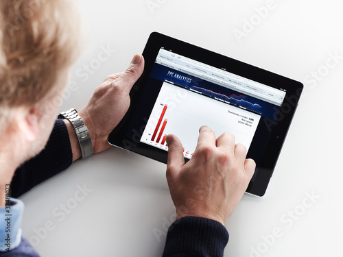Photo: Adult man doing analysis on his tablet pc Adult man doing analysis on his tablet pc