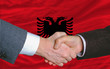 businessmen handshake after good deal in front of albania flag