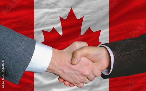 Photo: businessmen handshakeafter good deal in front of canada flag businessmen handshakeafter good deal in front of canada flag