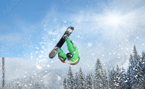 Photo: Snowboarder at jump inhigh mountains at sunny day Snowboarder at jump inhigh mountains at sunny day