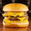 big cheeseburger with melted cheese and glittery background.