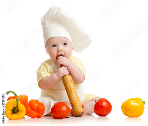 Photo: Portrait of a baby wearing a chef hat with healthy food vegetab Portrait of a baby wearing a chef hat with healthy food vegetab