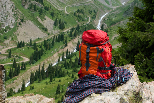 Photo: rucksack and rope on background of the mountain valley rucksack and rope on background of the mountain valley