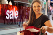 woman with shopping bags infront of shopping window