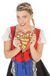 Blonde junge Frau im Dirndl mit Lebkuchenherz