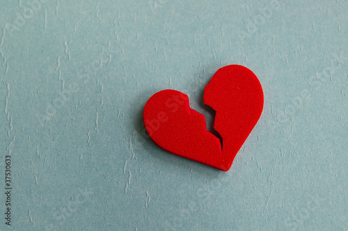 Photo: red broken heart, closeup on blue red broken heart, closeup on blue