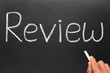 Writing review with white chalk on a blackboard.