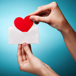 woman's hand holding an envelope with a sign of the heart agains